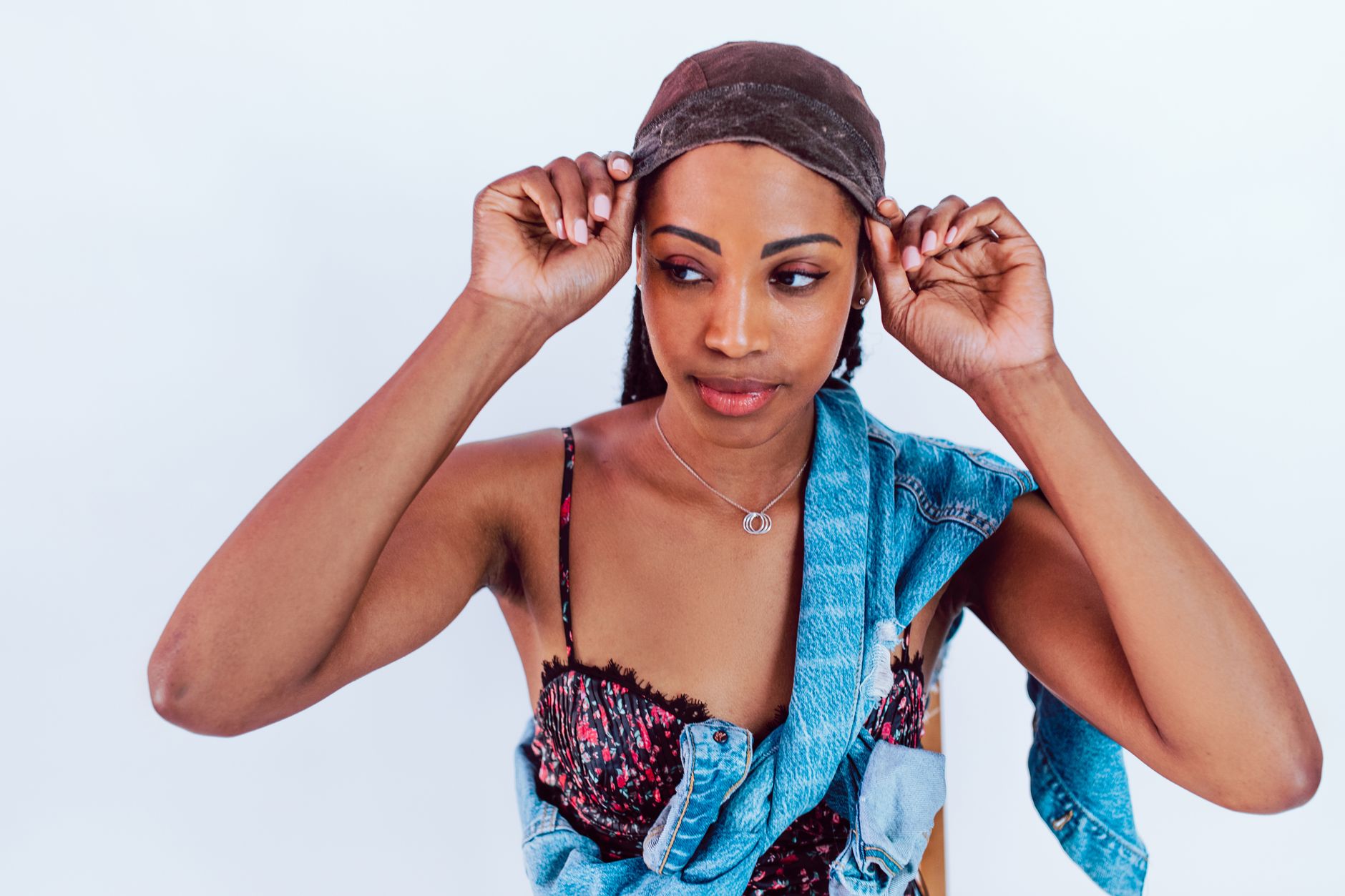 A young woman adjusts her wig with style, showcasing confidence and fashion.