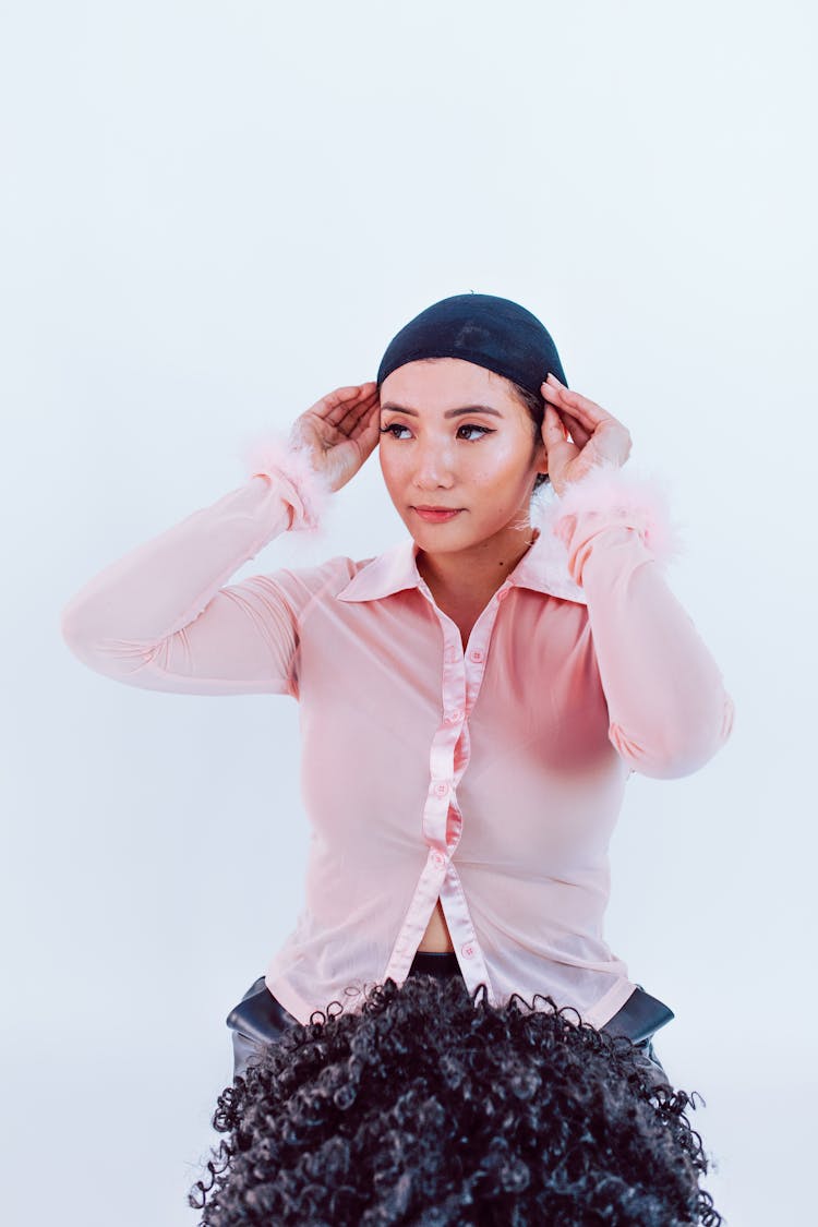 A Woman Putting On Wig Cap