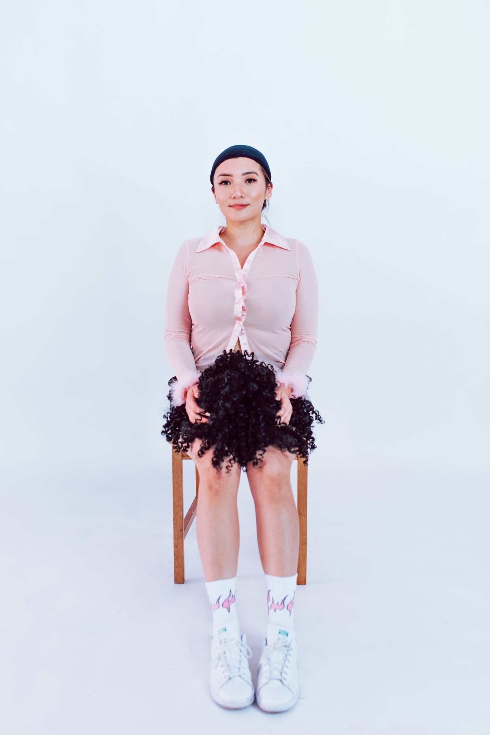 Woman with alopecia holding a wig