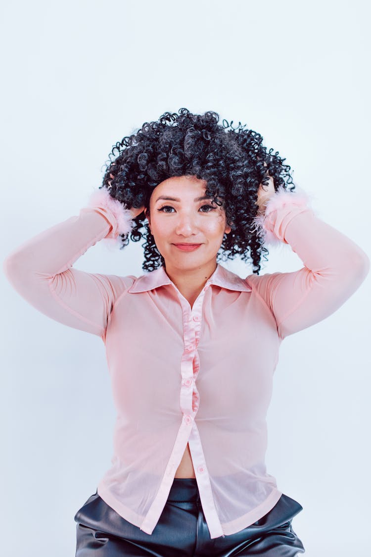 
A Woman Putting On Wig