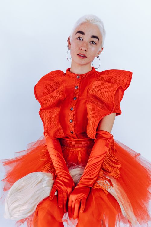 Free Elegant and artistic portrait of a woman in a striking red outfit with unique design elements. Stock Photo