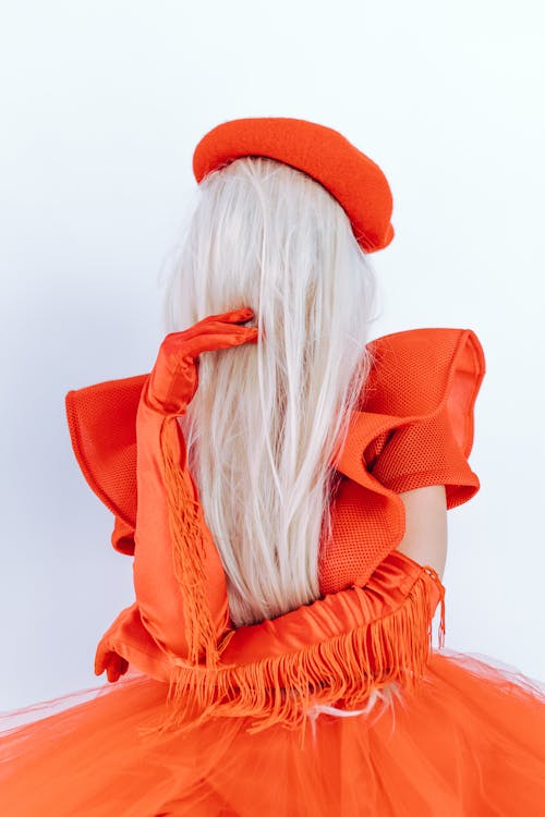 Woman in Orange Dress with Hair Covering Her Face