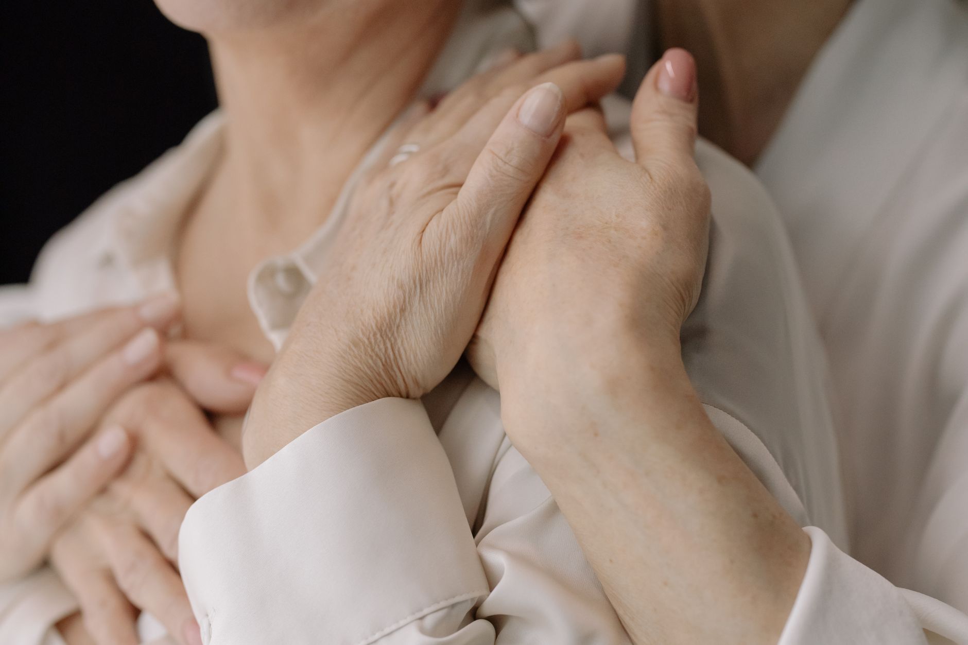 Close-up of elderly women's hands expressing love and connection, symbolizing intimacy and warmth.