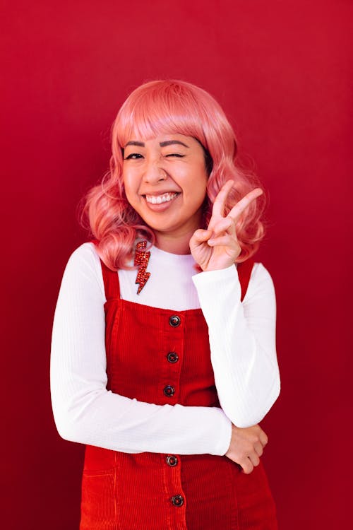 Photo of a Woman with Pink Hair Doing the Peace Sign