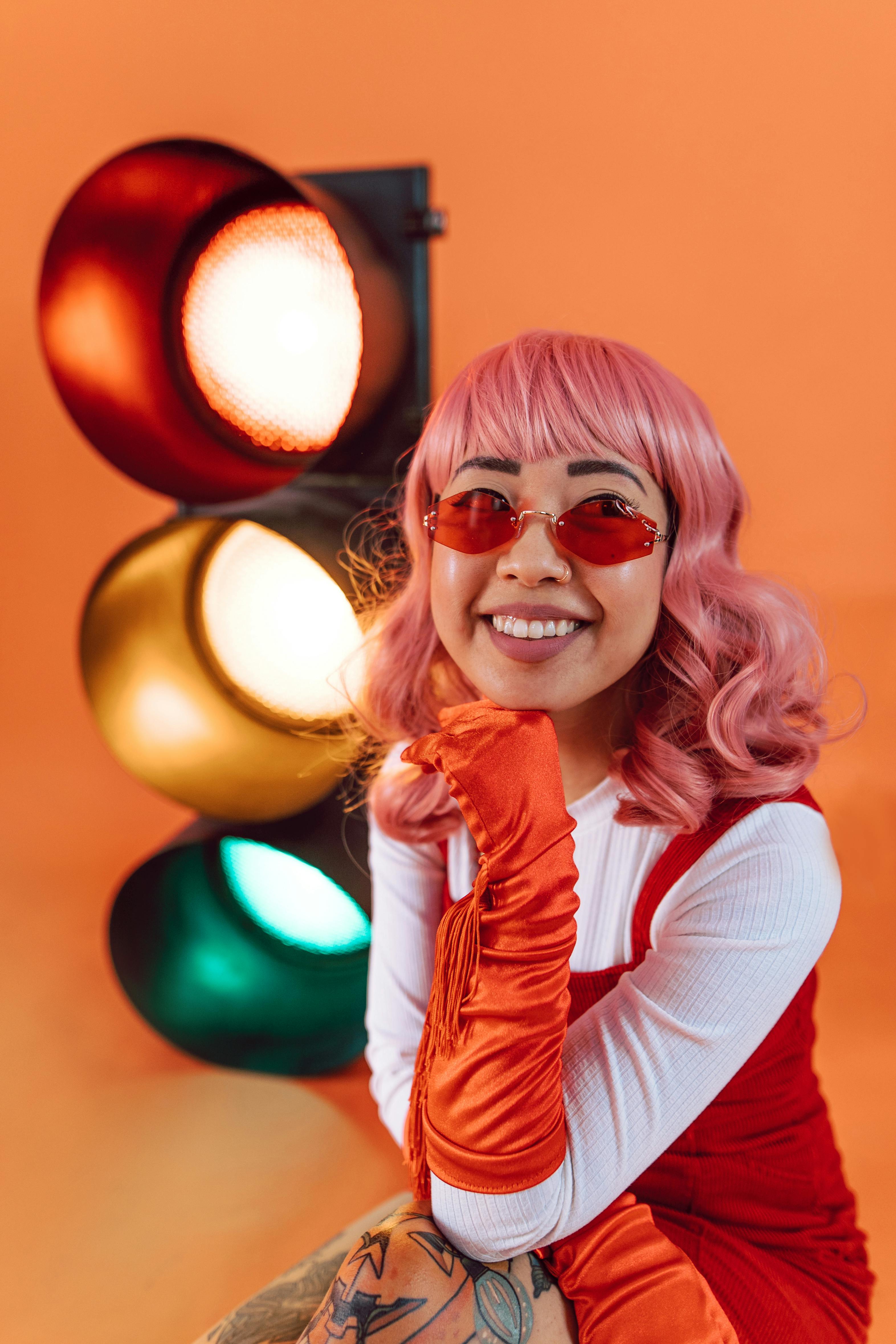 smiling woman in white long sleeve shirt wearing orange sunglasses