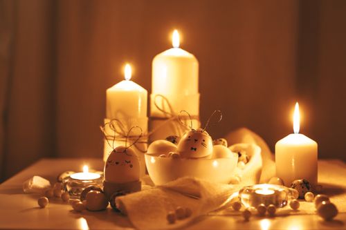 Free Warm Easter-themed setup with candles and decorated eggs creating a cozy atmosphere. Stock Photo