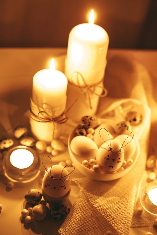 Free A warm, candlelit Easter scene with decorated eggs and candles creating a festive atmosphere. Stock Photo