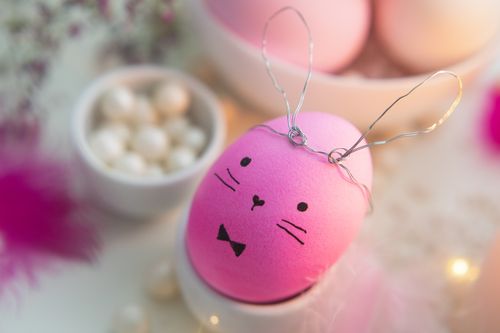 Free Close-up of a charming Easter bunny egg in pink with festive decorations creating a joyful holiday atmosphere. Stock Photo