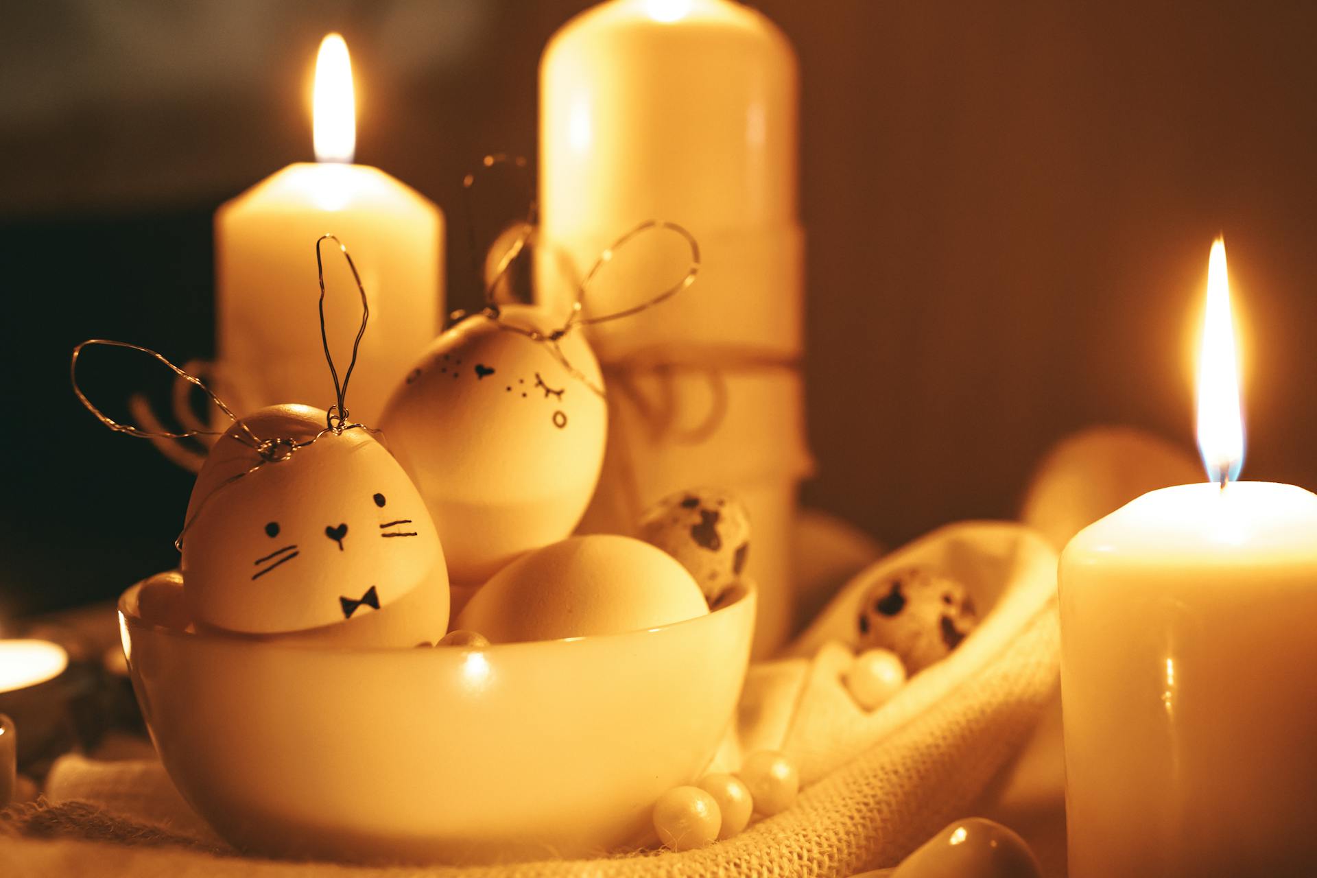 Warm Easter setting with painted eggs, candles, and bunny designs creating a cozy ambiance.