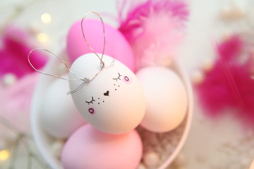 Decorated Easter eggs featuring a bunny design with pastel pink and white accents placed in a bowl.
