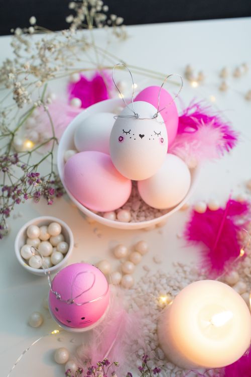 Free Delightful Easter egg decor in pink hues with candles and flowers, perfect for festive ambiance. Stock Photo