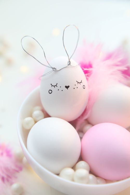 Free Cute Easter eggs with bunny theme and pastel decorations in a white bowl. Stock Photo
