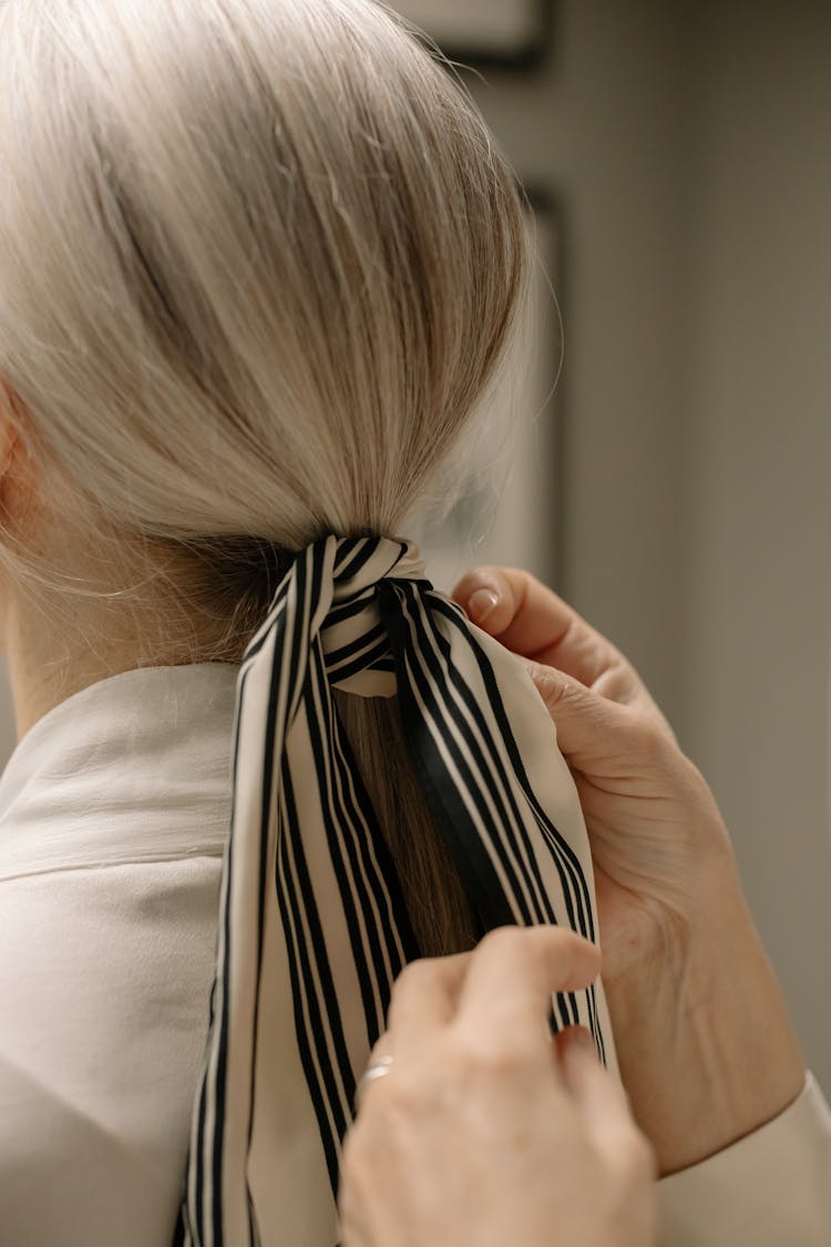 A Person Tying A Woman's Hair