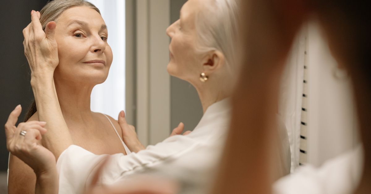 Chic elderly woman applying makeup, embracing beauty and confidence at any age.