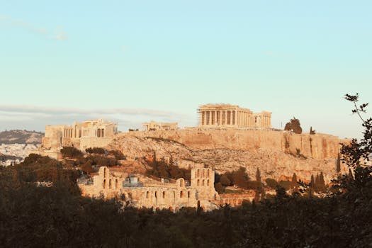 The iconic Acropolis of Athens, a UNESCO World Heritage Site, bathed in warm sunset light.