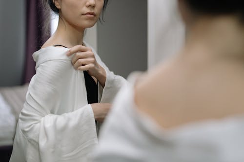 Woman Dressing and Looking at Herself in a Mirror