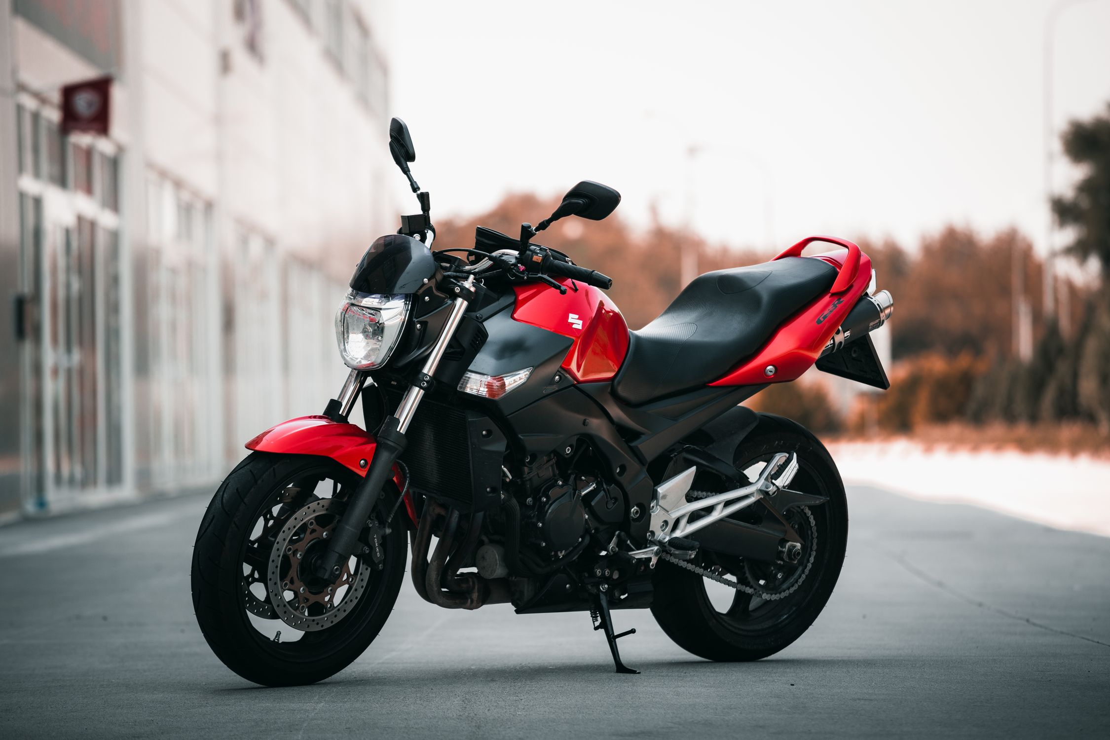 A Red And Black Suzuki Motorcycle Parked On The Street Free Stock Photo a-red-and-black-suzuki-motorcycle-parked-on-the-street-free-stock-photo