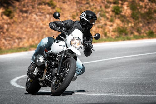 A Person in Black Leather Jacket Riding a Motorcycle