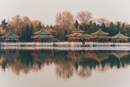 Free Peaceful scene of traditional Chinese architecture reflecting in a tranquil pond. Stock Photo