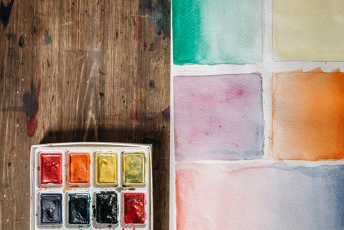 Free A watercolor palette with various color swatches on paper, ideal for artistic projects. Stock Photo