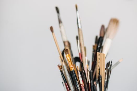 A variety of paintbrushes, pencils, and tools for creative art projects captured in a close-up.