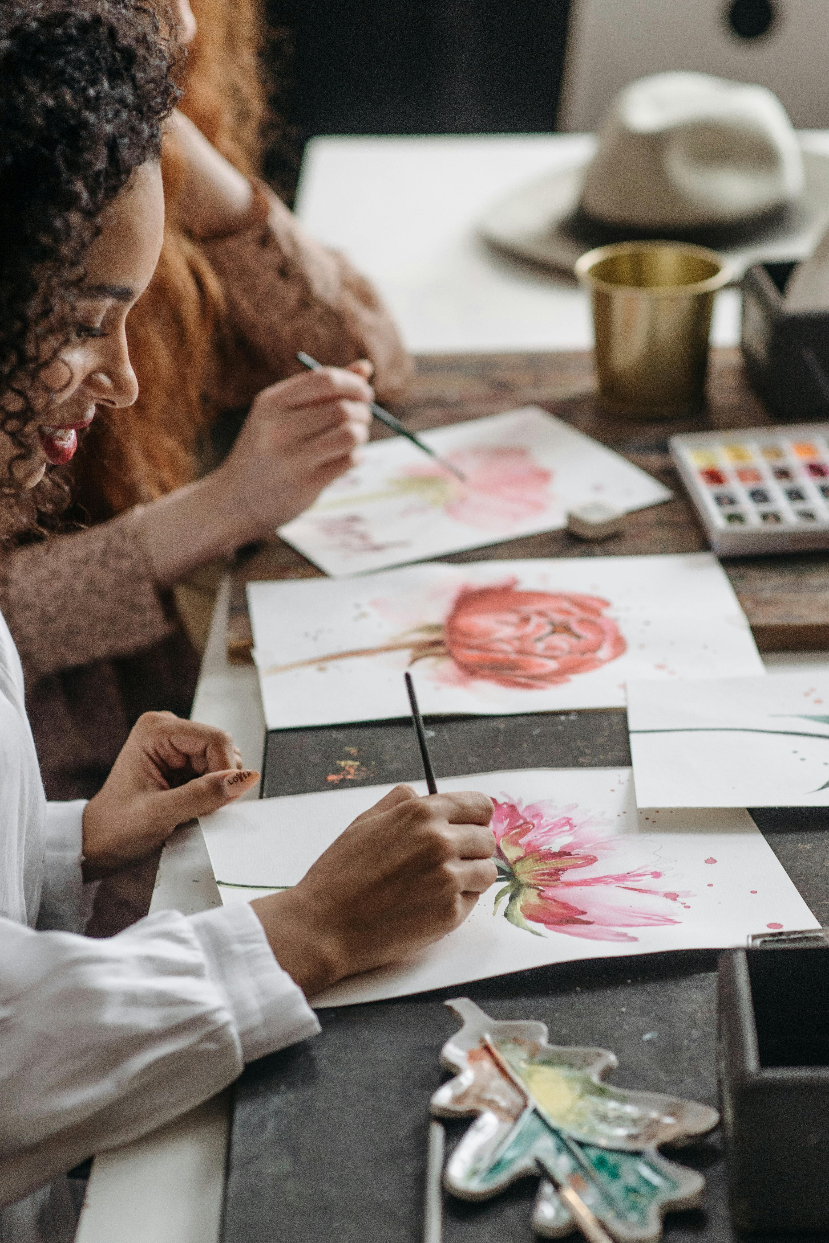 woman in white long sleeve shirt painting woman in pink and white floral
