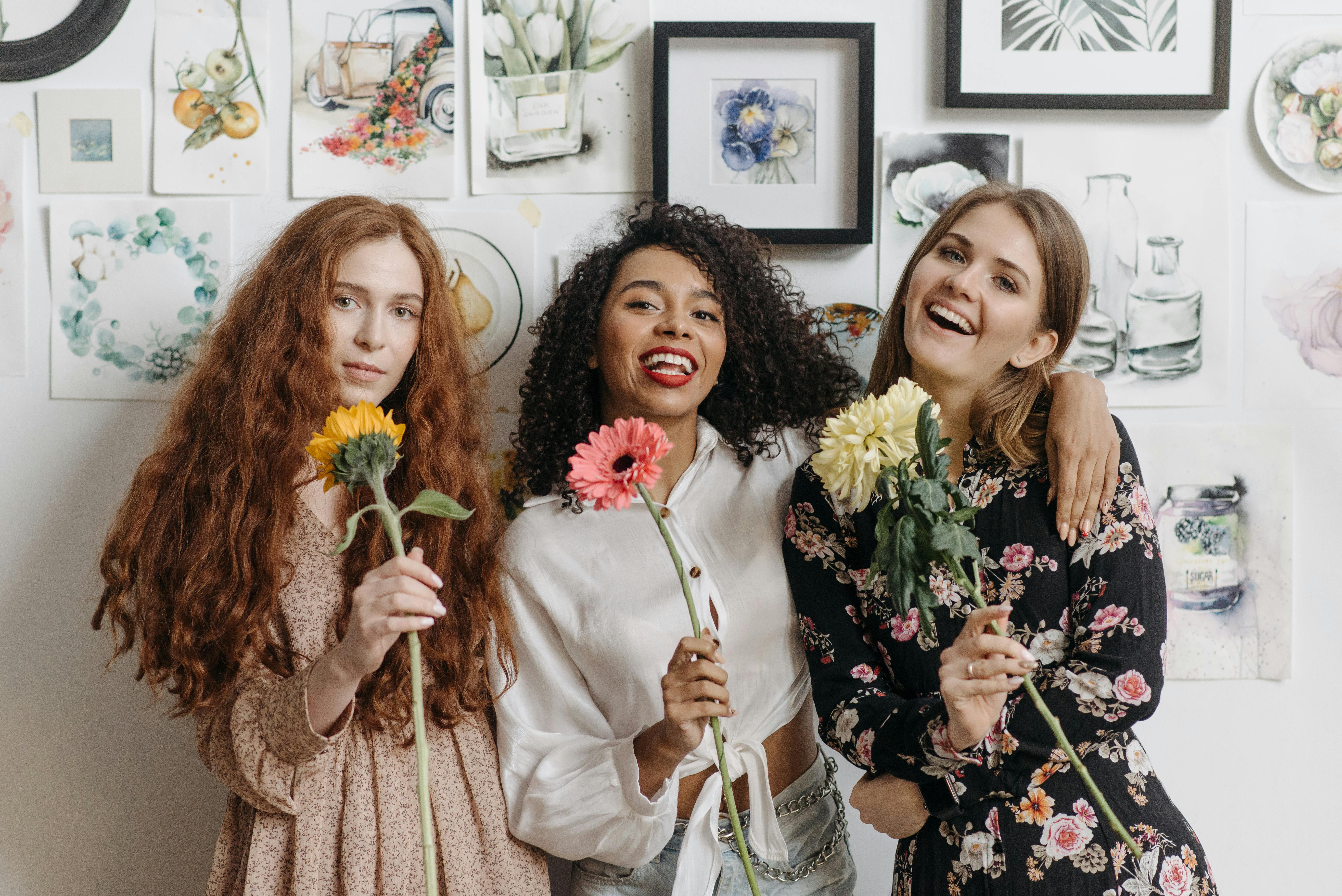 3 women holding flowers