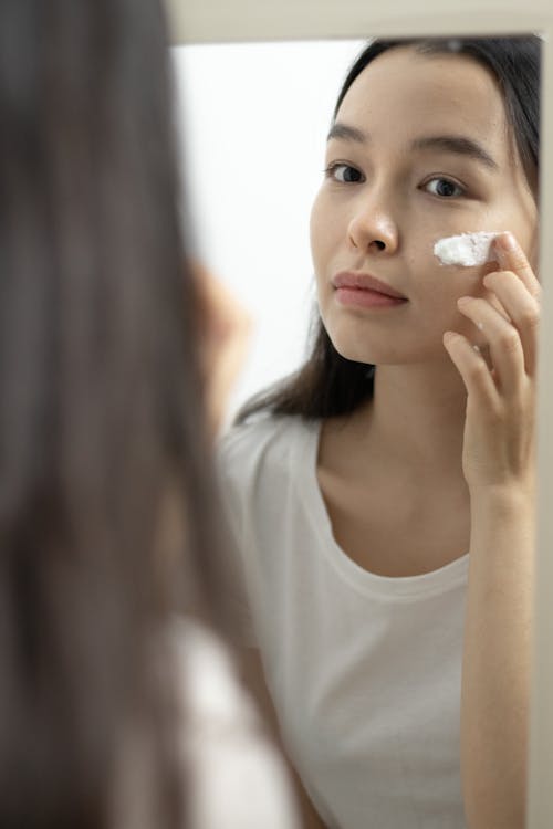 
A Woman Applying a Skin Care Product on Her Face