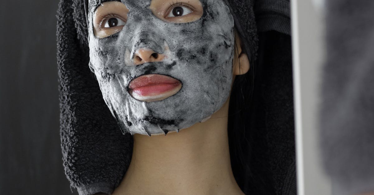 A woman applying moisturizer to her face.