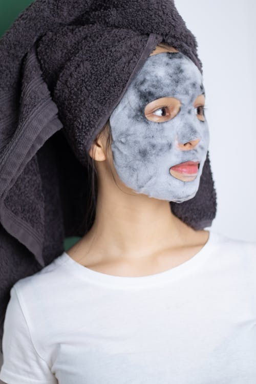 Woman Wearing A Head Towel and Sheet Mask On Face 