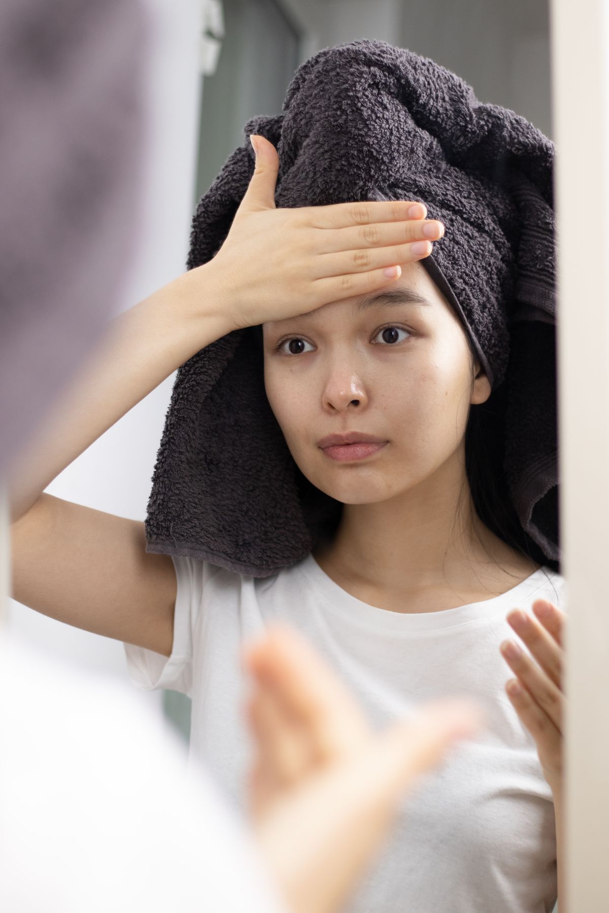 鏡の前でうるおいのある肌を確認する女性