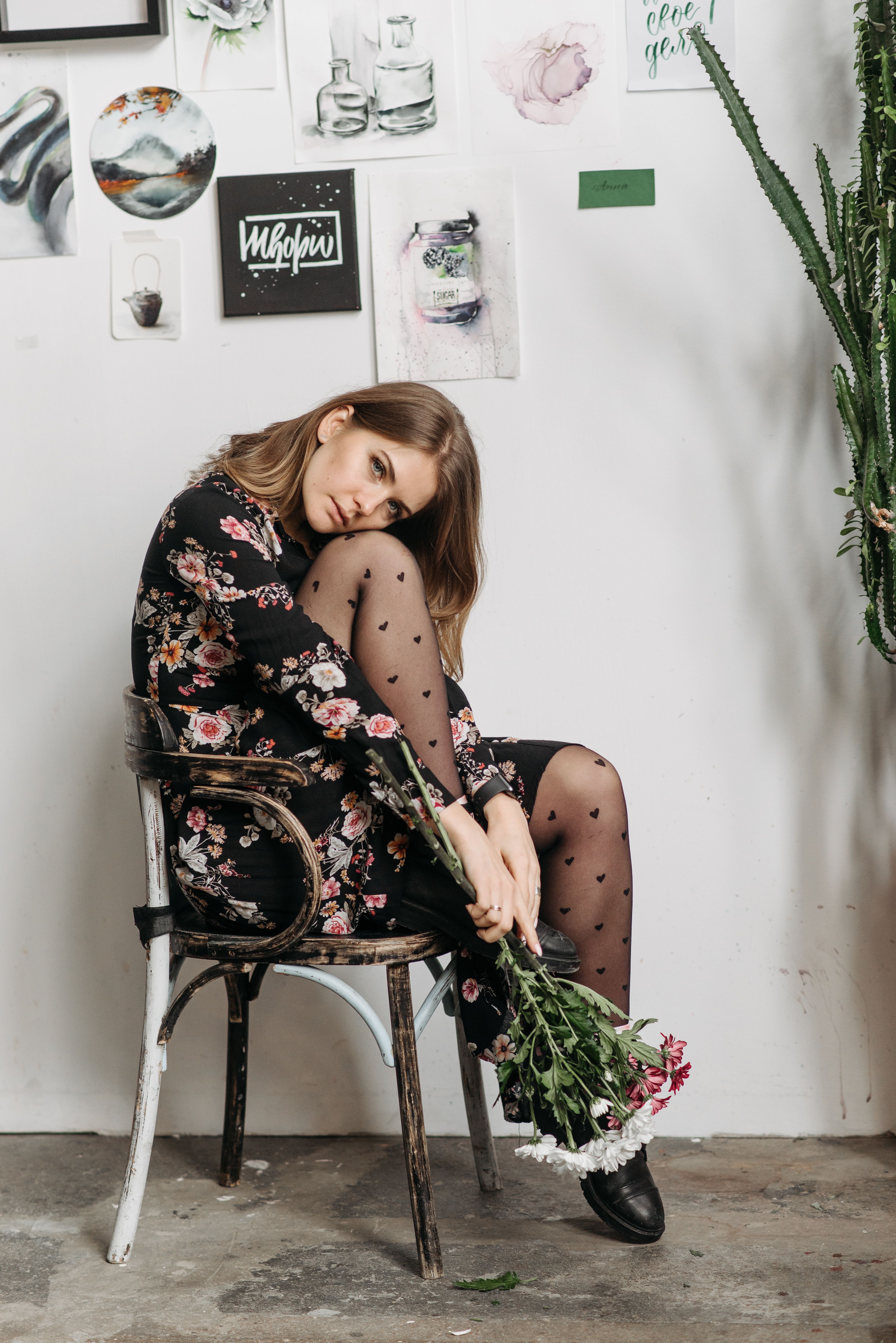A Woman in Black Floral Dress Sitting on a Chair Near the Wall · Free ...