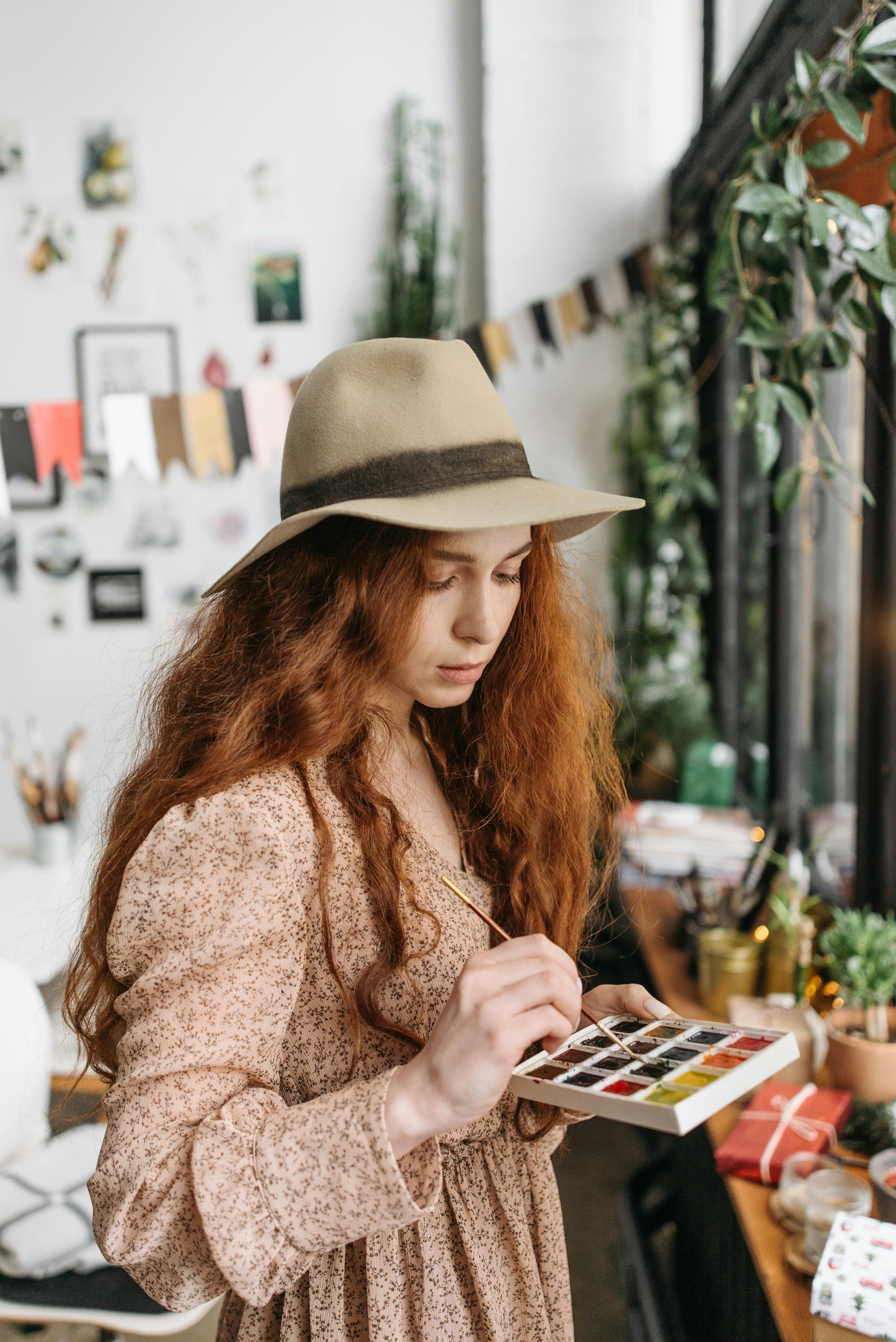 woman in brown sweater and beige hat sitting on chair