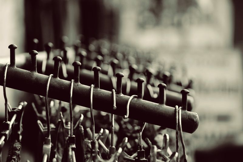 Stylish black and white photo of metal hangers neatly arranged on a rack