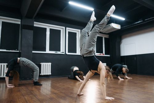 Free Group practicing flexibility and handstands in a modern dance studio. Stock Photo