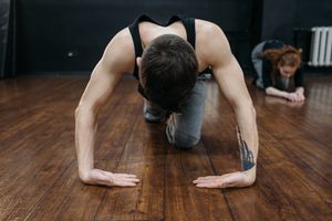Man practicing a lunge stretch on a studio floor — photo by Pavel Danilyuk on Pexels