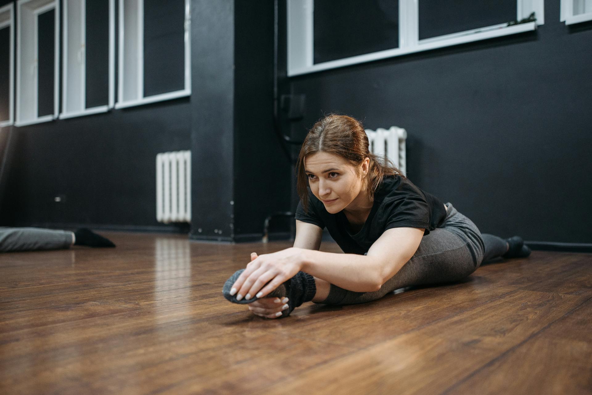 Woman in a Dance Studio Doing Leg Split