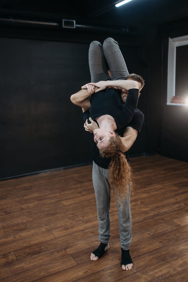 A Man Carrying A Woman Upside Down