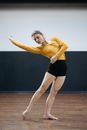 Woman in Yellow Long Sleeve Shirt Rehearsing a Dance