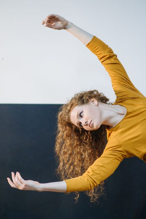 Free A woman gracefully dancing indoors, showcasing movement and emotion with an expressive pose. Stock Photo