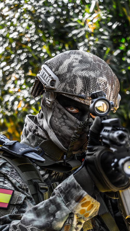 Free Person Wearing Black and Gray Camouflage Helmet and Black Helmet Stock Photo