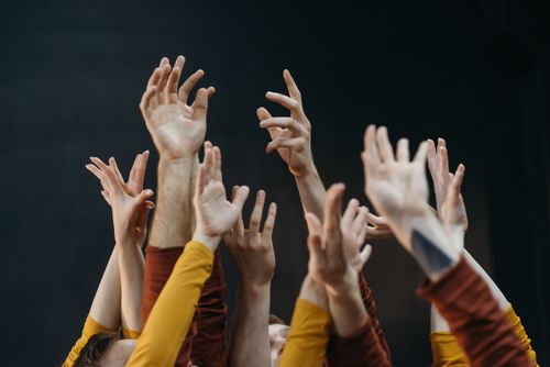 Free A vibrant image of raised hands symbolizing unity and movement against a dark background. Stock Photo
