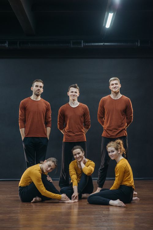 Free A group of young adults in colorful attire posing in a studio setting, showing unity and creativity. Stock Photo
