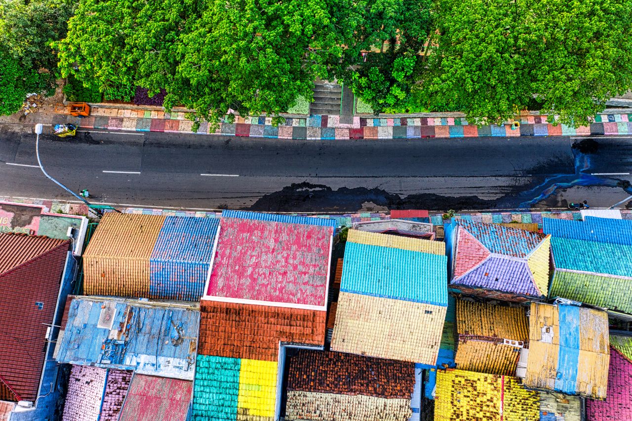 a vibrant aerial view of multicolored rooftops and a road in tangerang