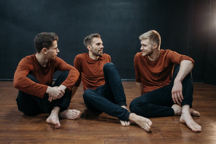 Men Talking While Sitting On The Wooden Floor 