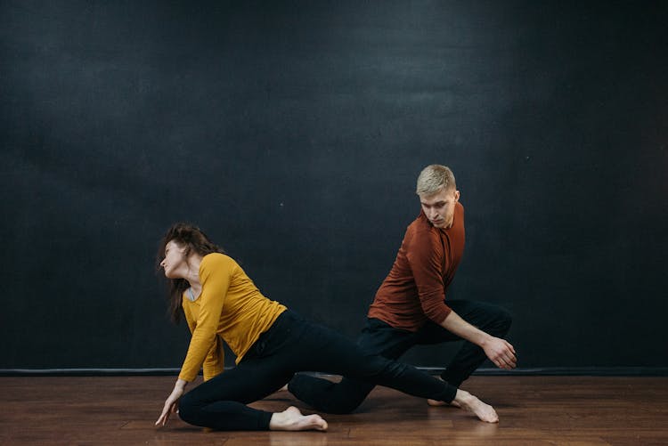 A Man And Woman In Black Pants Dancing Together