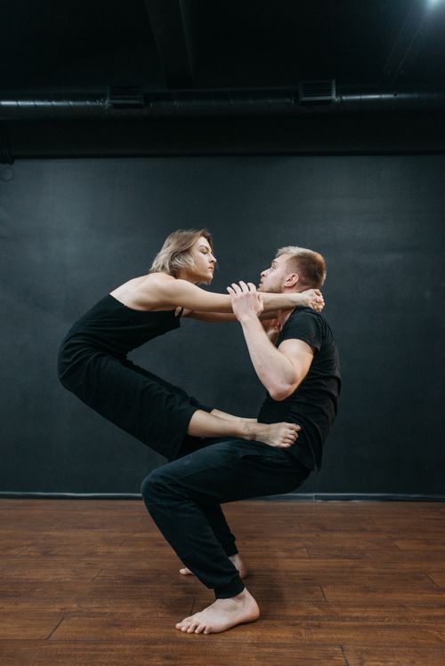 Free A couple in a dynamic dance pose in a studio showcasing flexibility and emotion. Stock Photo