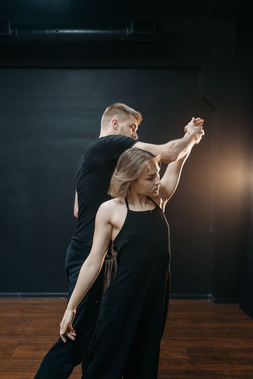 Free A male and female dancer execute a graceful movement in a studio setting. Stock Photo