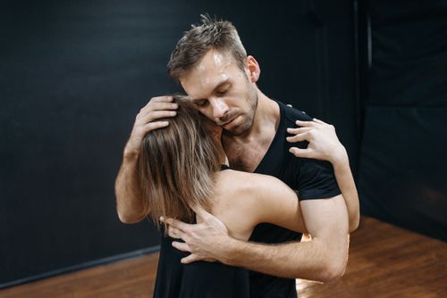 Free A couple sharing a romantic and intimate dance embrace indoors, expressing deep affection. Stock Photo