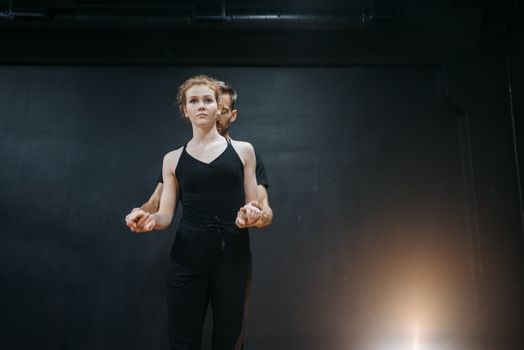 Graceful contemporary dance couple performing indoors. Captivating movement and synergy.
